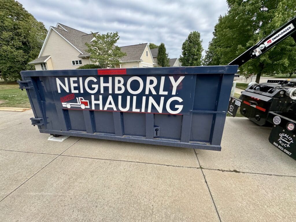 12 yard dumpster rental placed on a residential driveway by Neighborly Hauling