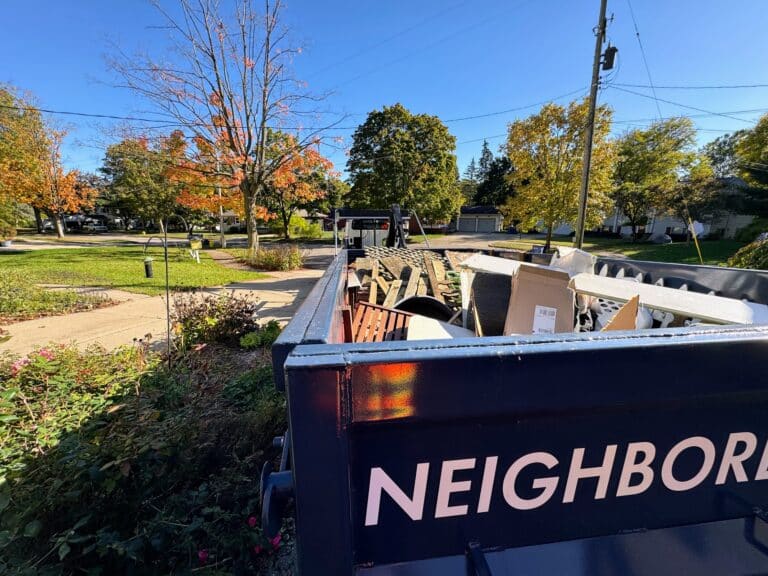 Neighborly Hauling dumpster filled with construction debris in a residential neighborhood in West Michigan.