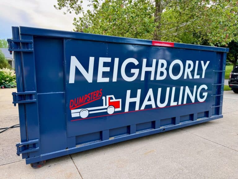 Neighborly Hauling blue commercial roll-off dumpster on a driveway in Grand Rapids, Michigan.
